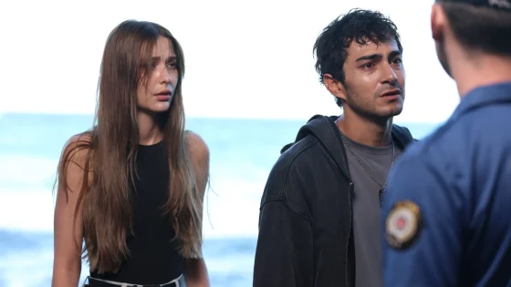Two young adults having a serious conversation with a police officer at the beach.